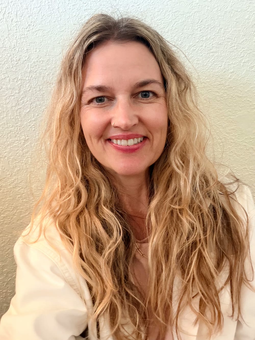 Portrait of Amy Pescaglia, LPC, MEd, E-RYT, smiling.